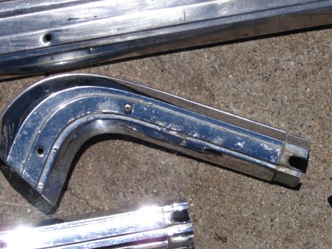 1973 Ford Ranchero - Close-up of damaged chrome trim parts, suggesting they are from an older vehicle.