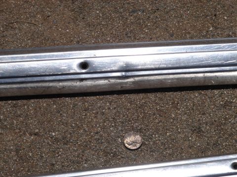 1973 Ford Ranchero - A dime sits on the ground next to a damaged chrome trim piece.