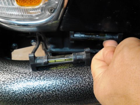 1993 Toyota Pickup/SR5 - A bubble level tool is used to check alignment on a vehicle part. The Supermotors.net logo is in the corner.