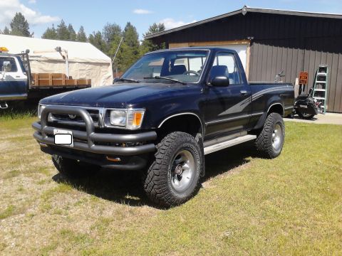 1993 Toyota Pickup/SR5 - This black 1993 Toyota Pickup SR5 is equipped with a brush guard and large off-road tires.