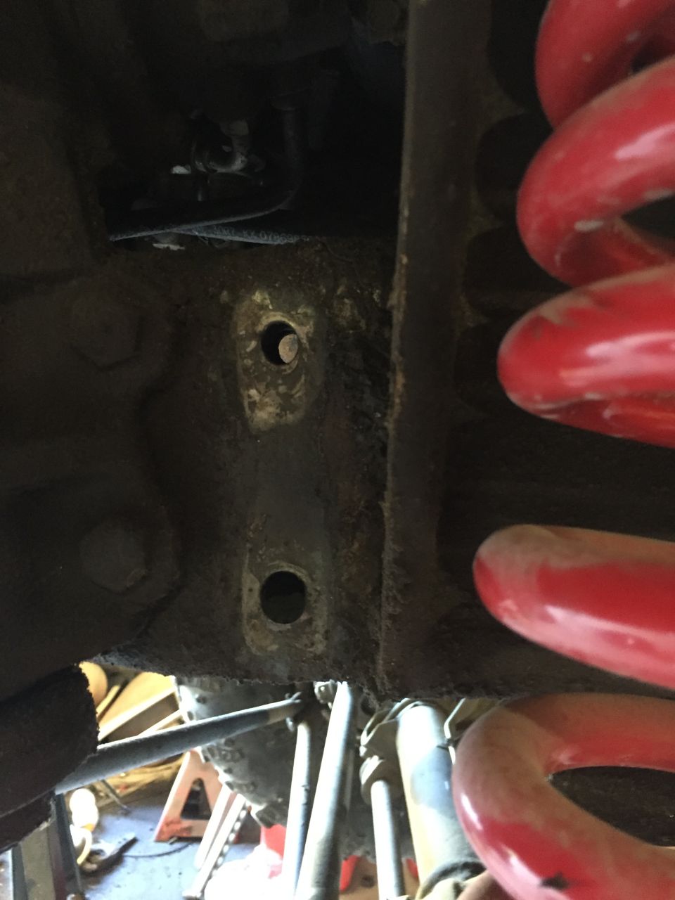 Close-up of vehicle suspension showing red coil springs and mounting points