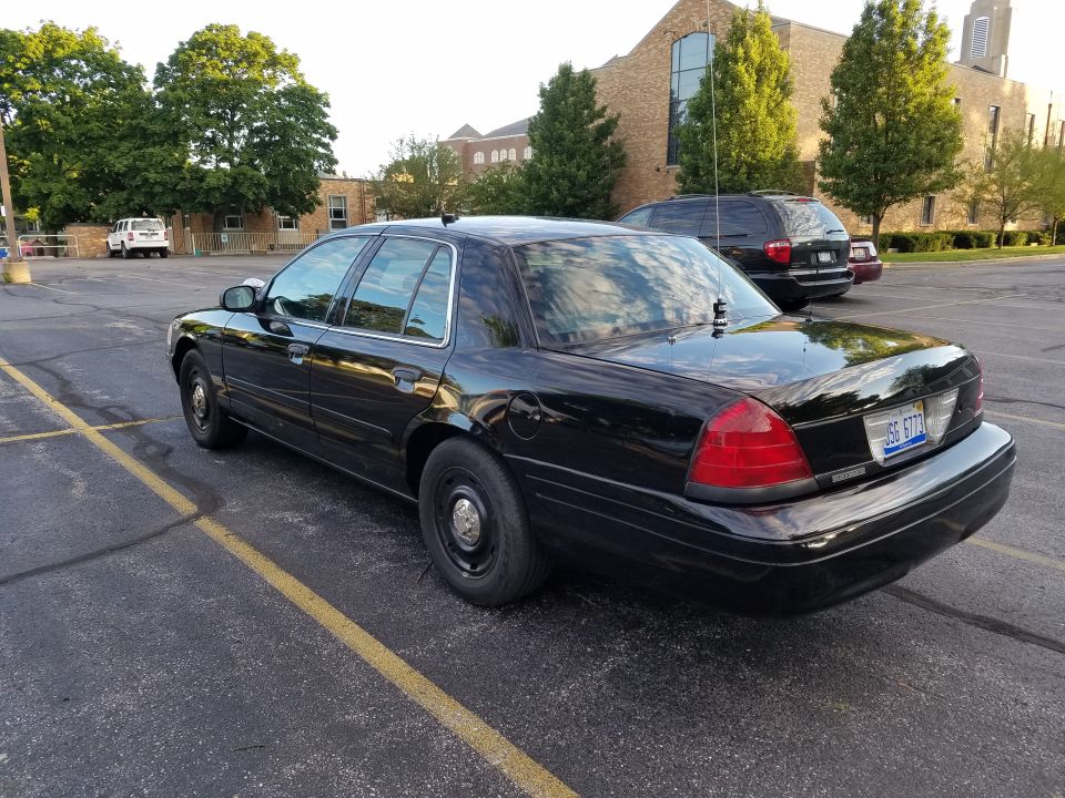 2004 Ford Crown Victoria P71 sedan parked in lot, rear view. License plate reads JSS 6772