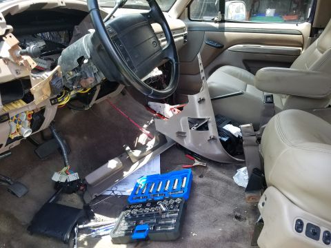 1994 Ford Bronco - The interior of a 1994 Ford Bronco shows a disassembled dashboard and tools laid out for repair.