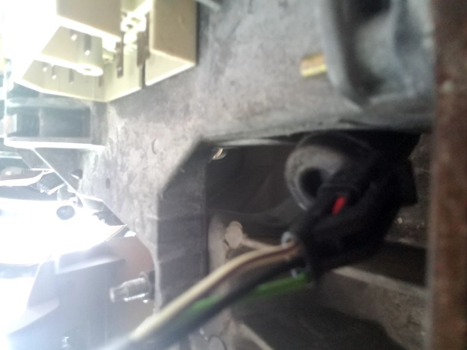 Close-up of a black wiring harness connector with red and green wires