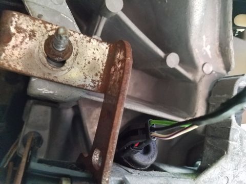 1994 Ford Bronco - Close-up of a wiring harness connector attached to a vehicle's transmission housing.