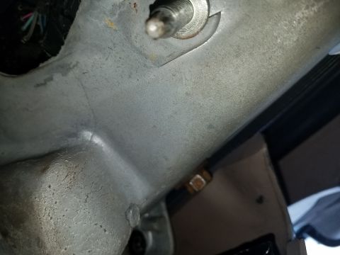 1994 Ford Bronco - A close-up view of a metal bracket and wiring harness inside a vehicle's cabin.