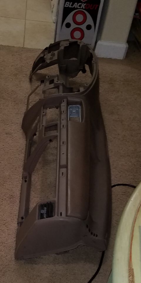 1994 Ford Bronco - Disassembled dashboard frame, likely for a vehicle, lies on a carpeted floor with a "BLACKOUT" box in the background.