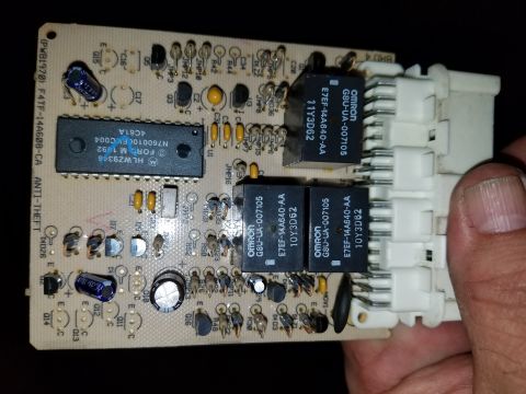 1994 Ford Bronco - Circuit board with "FORD M 1992" text and Omron relays is held by a hand.