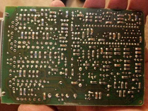 1994 Ford Bronco - A circuit board, likely an electronic control unit, is held in hand.