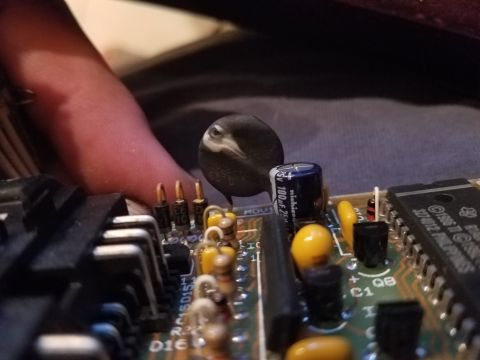 1994 Ford Bronco - Close-up of electronic components on a circuit board, with a finger obscuring part of the view.