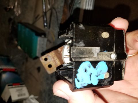 1994 Ford Bronco - An automotive electrical part is held in a hand, showing its internal components and some blue markings.