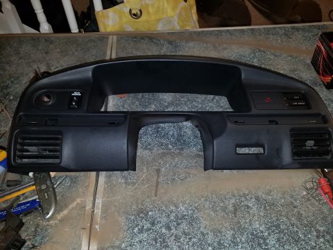 1994 Ford Bronco - This dashboard assembly is out of a vehicle and sitting on a workbench.