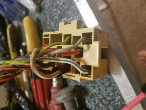 1994 Ford Bronco - Photograph of a yellow multi-pin electrical connector with colored wires on a workbench.