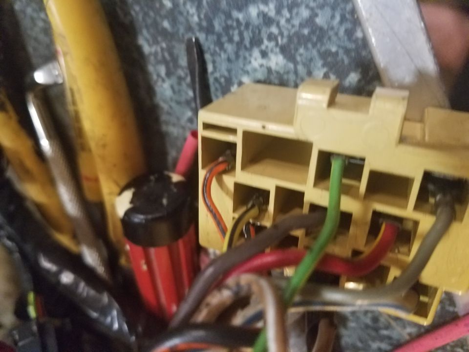 Close-up photo of a tan multi-pin wiring connector and colored wires