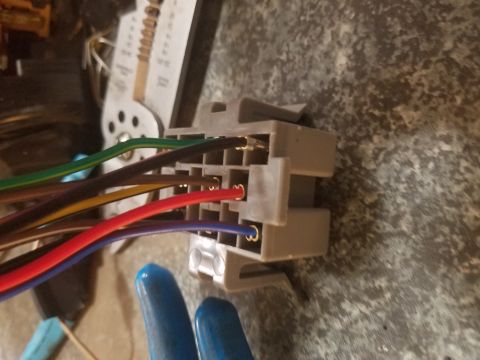 1994 Ford Bronco - Photograph of a gray multi-pin connector with gold terminals and colored wires.
