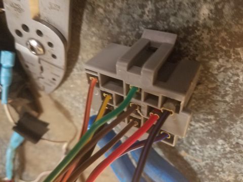 1994 Ford Bronco - Photograph of a gray electrical connector with colored wires beside a hand tool.