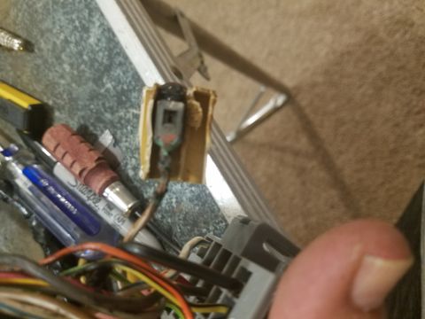 1994 Ford Bronco - Photograph of an automotive electrical connector and wiring harness on a workbench, not a technical document.