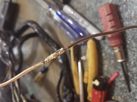 1994 Ford Bronco - Photograph of a soldered automotive wire splice resting on a workbench, not a technical document.
