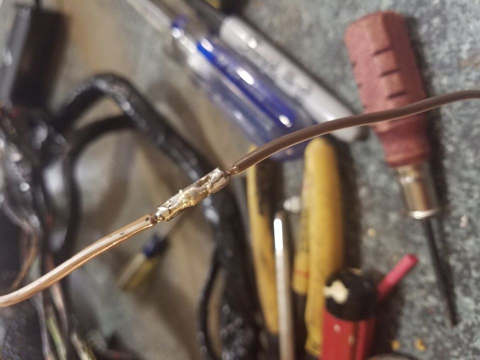 Close-up photo of a soldered wire splice on a workbench