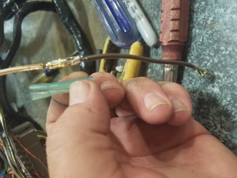 1994 Ford Bronco - Photograph of a hand holding a repaired automotive wire splice and terminal, not a technical document.