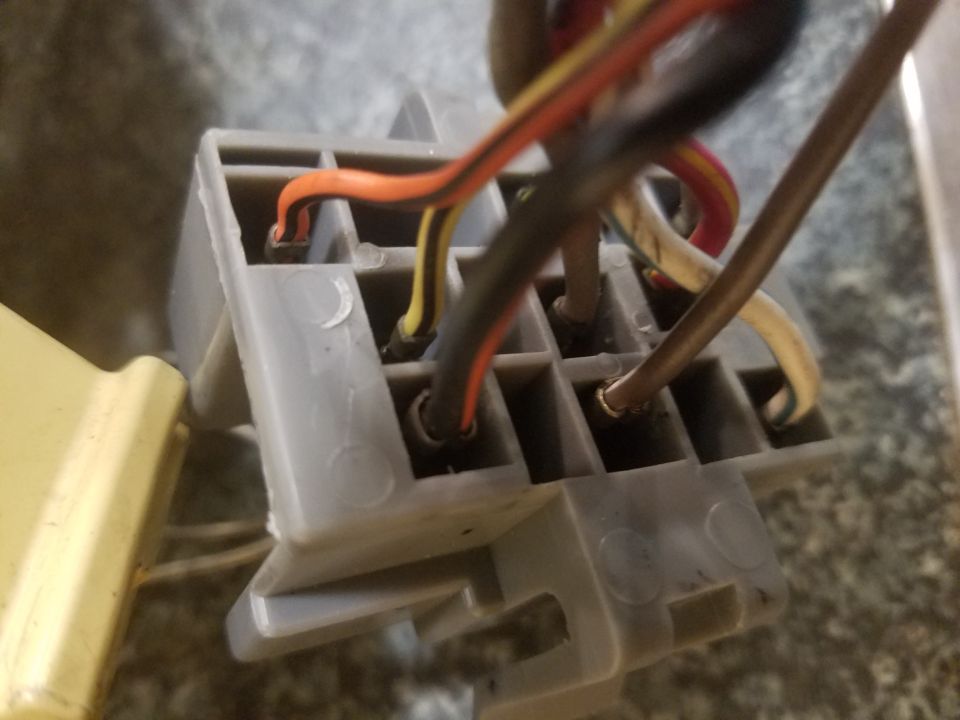 Close-up photo of a gray connector block with colored wires inserted