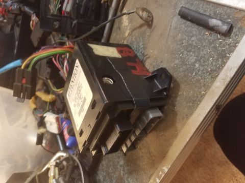 1994 Ford Bronco - Photograph of an automotive electronic control module beside a wiring harness, not a technical document.