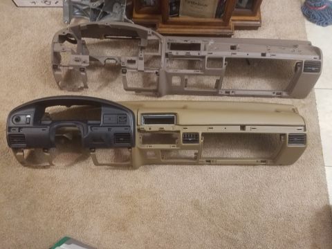 1994 Ford Bronco - Photograph of two vehicle dashboard panel assemblies laid on carpet, not a technical document.