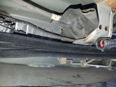 1994 Ford Bronco - Photograph of an automotive undercarriage area showing steering linkage and brackets, not a technical document.