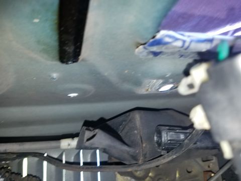 1994 Ford Bronco - Photograph of an automotive interior floor and underside area, not a technical document.