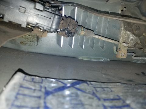 1994 Ford Bronco - Photograph of a corroded automotive steering component above a paper, not a technical document.