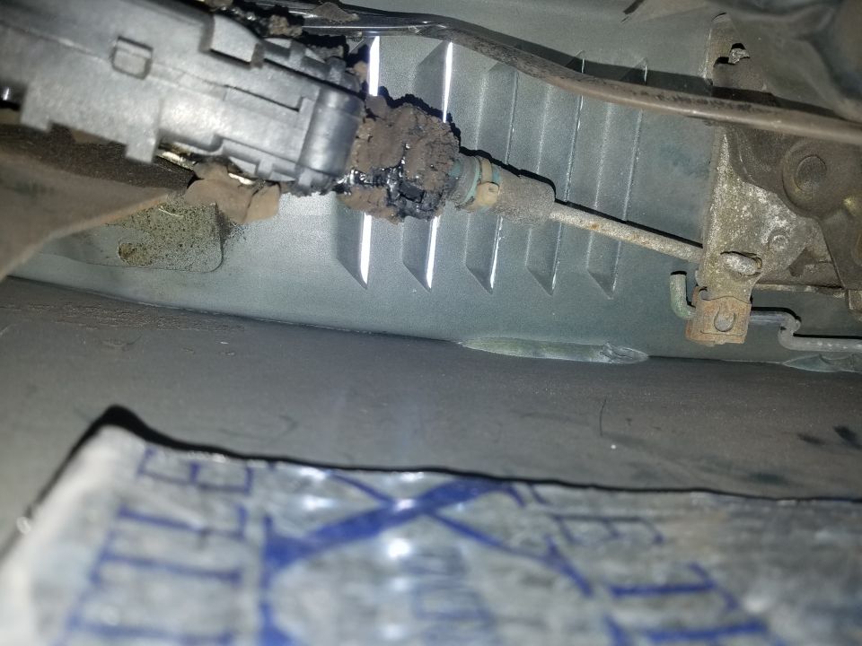 Photo of a corroded steering component over a paper on the floor