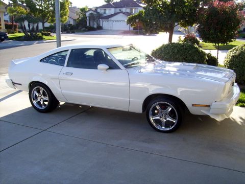 1978 Ford Mustang II - This white coupe is parked in a suburban driveway on a sunny day.