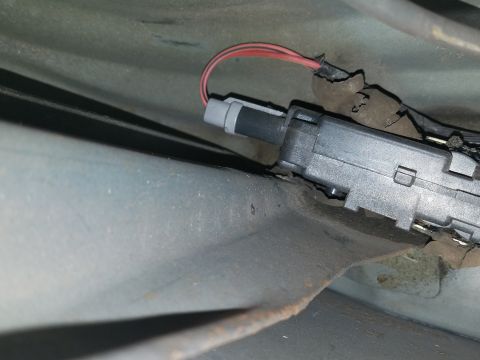 1994 Ford Bronco - Photograph of an automotive switch or actuator with a red wire under the dash, not a technical document.