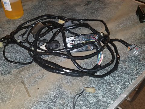 1994 Ford Bronco - Photograph of a large automotive wiring harness coiled on a workbench, not a technical diagram.
