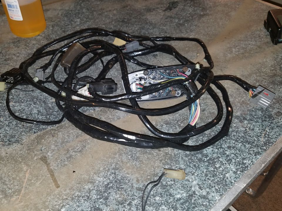 Photo of a large vehicle wiring harness coiled on a workbench