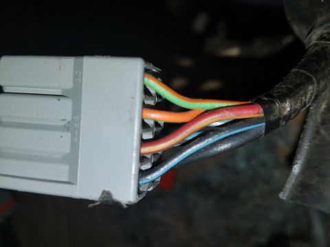 1994 Ford Bronco - Photograph of a gray multi-pin electrical connector with color-coded wires, not a document.