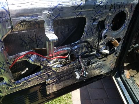 1994 Ford Bronco - Photograph of a vehicle door interior with sound-deadening mat and wiring, not a diagram.