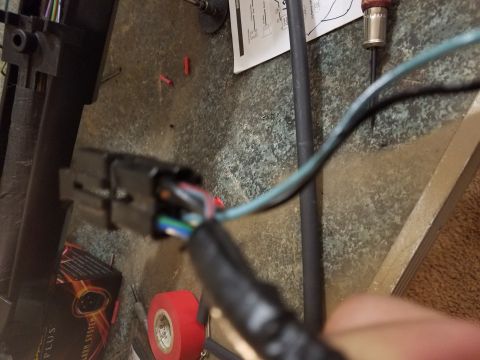 1994 Ford Bronco - Photograph of a hand-held electrical connector on a workbench, not a technical document.