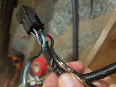 1994 Ford Bronco - Photograph of a hand-held electrical connector with taped wiring, not a document.