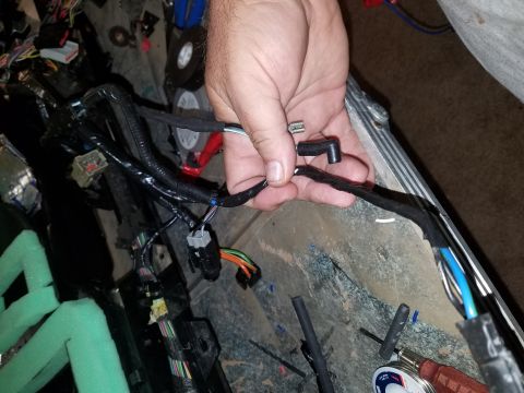 1994 Ford Bronco - Photograph of a wiring harness being handled during dash work, not a technical document.
