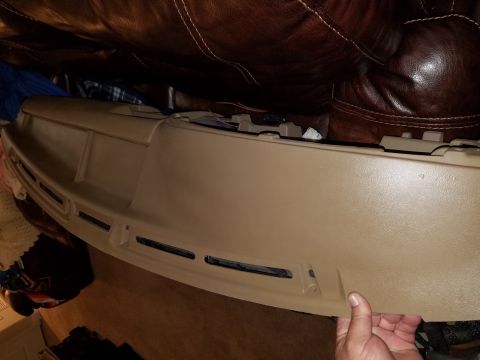 1994 Ford Bronco - Photograph of a tan dashboard defroster trim panel, not a technical document.