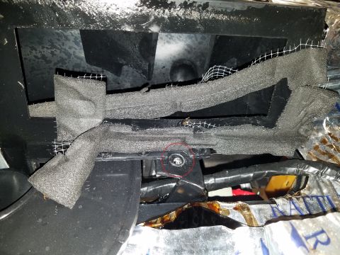 1994 Ford Bronco - Photograph of foam HVAC vent seals under the dash with a marked bolt, not a technical document.