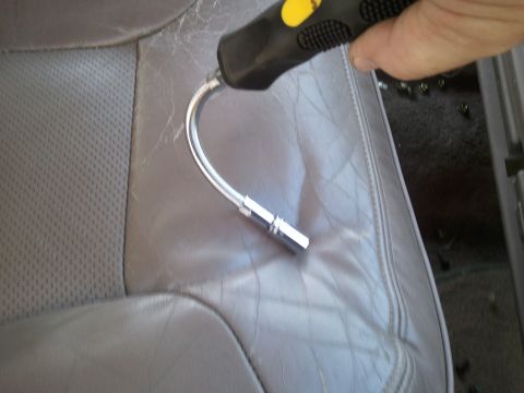 1994 Ford Bronco - Photograph of a flexible magnetic pickup tool resting on a worn gray leather car seat, not a technical document.