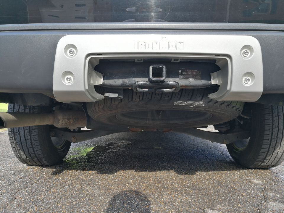 Rear view of a vehicle's hitch and spare tire with Ironman branding.