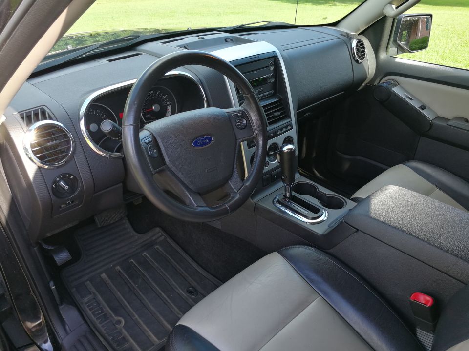 Interior of a Ford Explorer showing steering wheel, dashboard, center console, and seats.