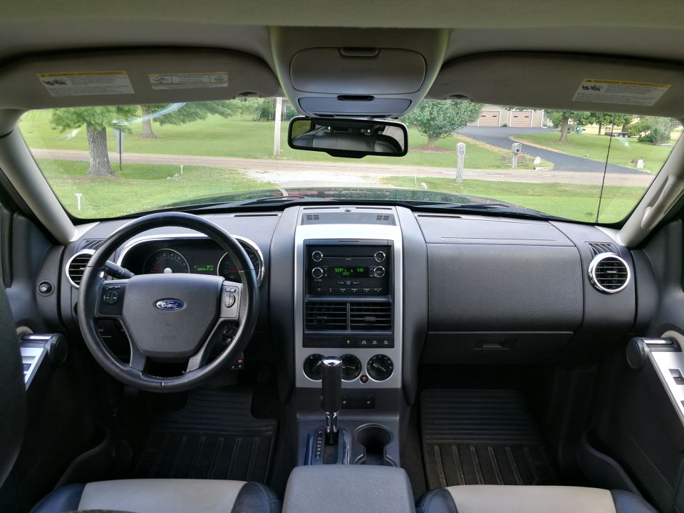 Interior view of a Ford Explorer dashboard with steering wheel, radio, and climate controls.