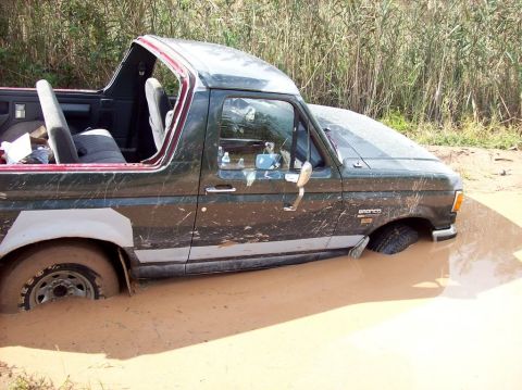 1989 Ford Bronco - This Ford Bronco is stuck deep in the mud, with its driver's side and front end submerged.