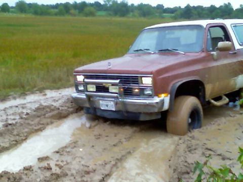 1989 Ford Bronco - This SUV is stuck in a muddy field, with its front tire deep in the mire.