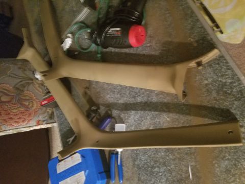 1994 Ford Bronco - Two tan interior trim pieces are shown on the floor next to various tools and a power tool.