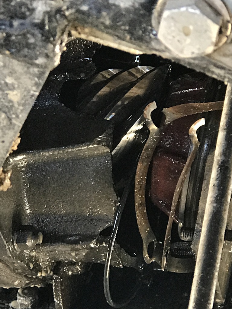 Close-up of engine internals with gears and metal components covered in oil